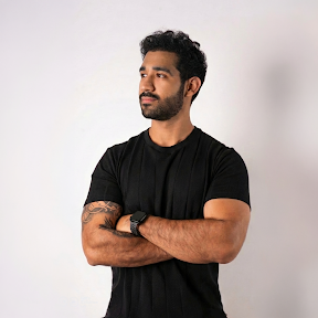 Retrato de estudio de Anthony Villegas con camiseta negra y los brazos cruzados sobre fondo claro